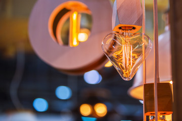 A beautiful Edison light bulb in the shape of a heart. Festive cute heart shaped chandelier