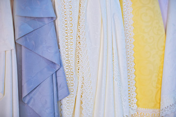Waterproof silk tablecloths in the store. Openwork fine beautiful fabrics, textures
