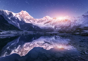 Photo sur Plexiglas Manaslu Night scene with himalayan mountains and mountain lake at starry night in Nepal. Landscape with high rocks with snowy peak and sky with stars and moon reflected in water. Moonrise Beautiful Manaslu