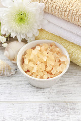 Bowl of yellow sea salt and stack of towels.