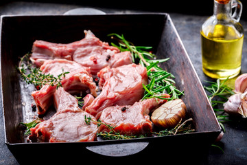 Meat Raw Fresh Mutton on the bone Spices Chesno and Rosemary on a black background pan