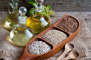  seeds of flax, sesame seeds, sunflower seeds on a wooden table. oil is rich in omega-3 fatty acids, diet.