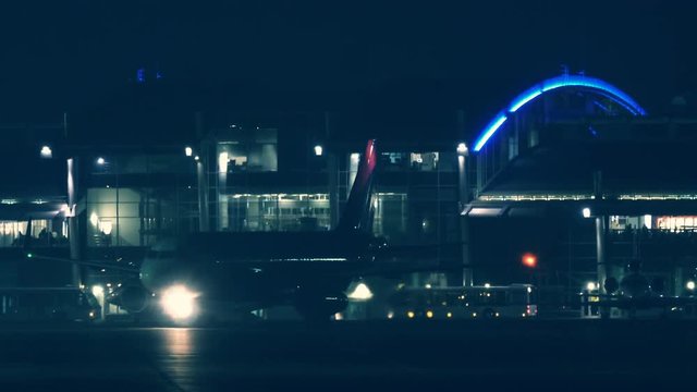 The aircraft with lights on maneuvers along the runway before take-off at night