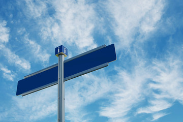 Blank directional road signs over blue sky with clouds.
