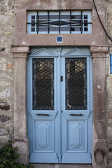 Close up view of old, rusty, blue door and stone wall of histori