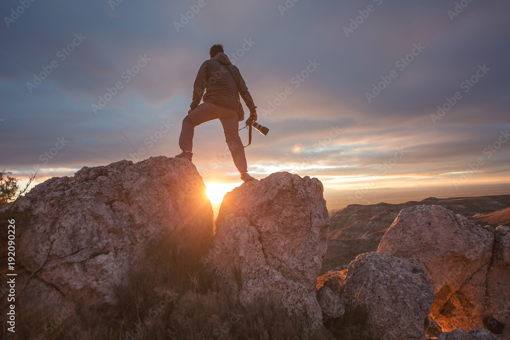 Wall mural photographer in mountain at sunset