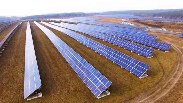 Drone flight over a solar power plant in agricultural landscape. Industrial background on renewable resources theme. Industry of power and fuel generation in European Union. 