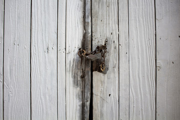 White, old, rusty, typical locked wooden door in old town of Cun