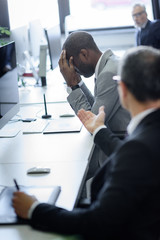 selective focus of stressed african american businessman and arguing colleague in office