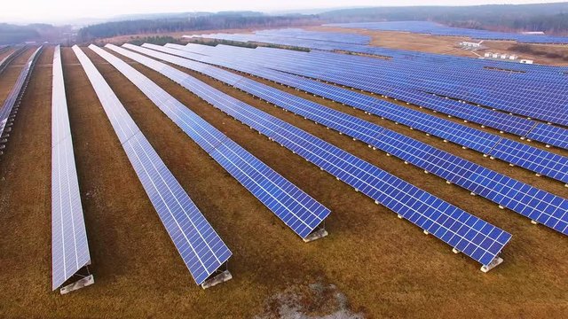 Drone flight over a solar power plant in agricultural landscape. Industrial background on renewable resources theme. Industry of power and fuel generation in European Union. 