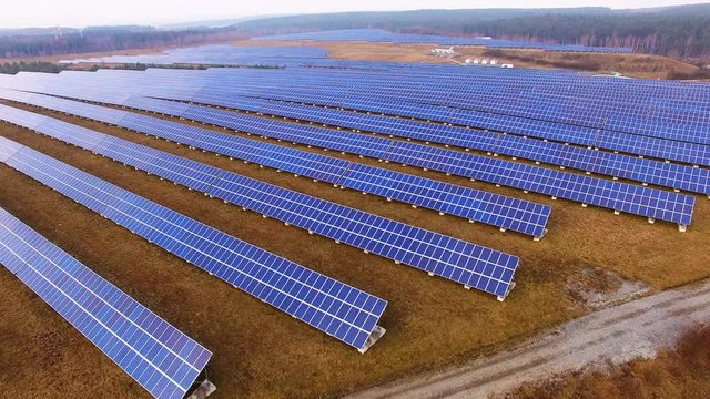 Drone flight over a solar power plant in agricultural landscape. Industrial background on renewable resources theme. Industry of power and fuel generation in European Union. 