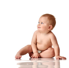 Infant child baby boy toddler sitting naked in diaper with green brick toy looking up