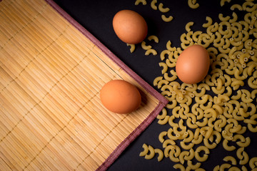 pasta with eggs on black background