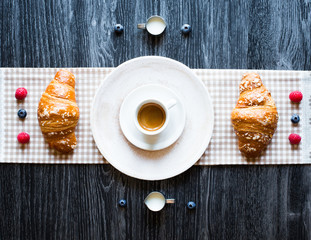 Top view of a wood table full of cakes, fruits, coffee, biscuits, spices and more