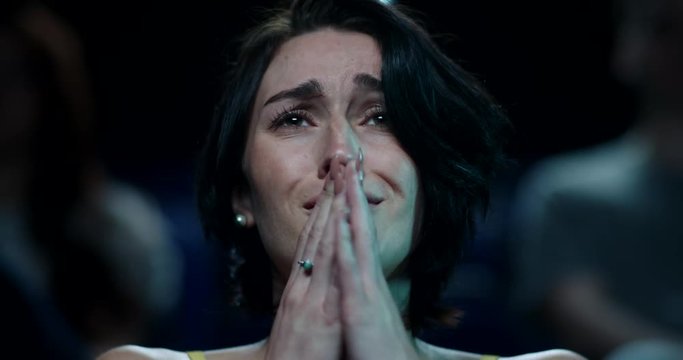Woman at the cinema beings to cry while watching a sad and emotional movie