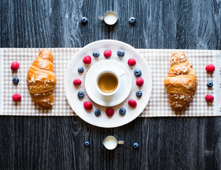 Top view of a wood table full of cakes, fruits, coffee, biscuits, spices and more