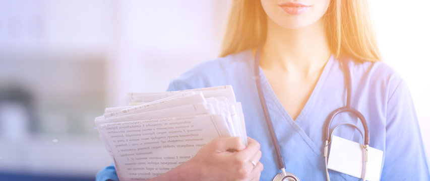 Doctor woman is standing in the near window