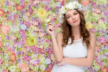 beautiful young woman in floral wreath with blossoming rose bud