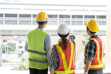 engineers visit the construction site.Examining blueprint with construction manager.