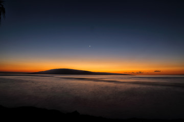 Fototapeta na wymiar Moonset over Lanai from Baby Beach on Maui.