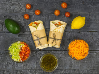Two vegetable rolls and vegetarian products on a dark wooden table. Vegetarian food.