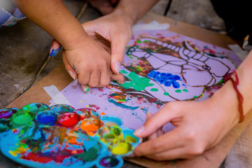 Children finger and Teacher paints on a paper. Children use finger playing colorful paints.