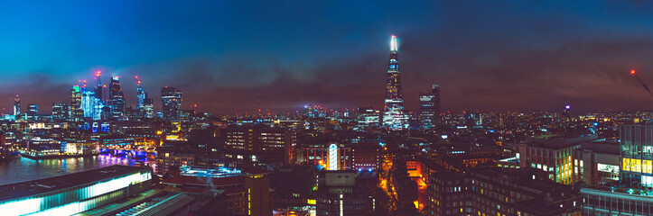 big panorama picture of london cityscape at night with thames river and shard