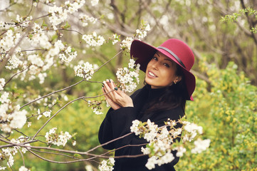 Portrait of a young woman in a blossoming spring garden