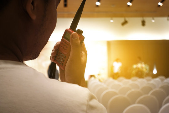Man with a Walkie Talkie or Portable radio transceiver for communication at event