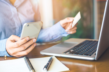 Business woman hand  hold use cell phones and credit cards to make purchases online.