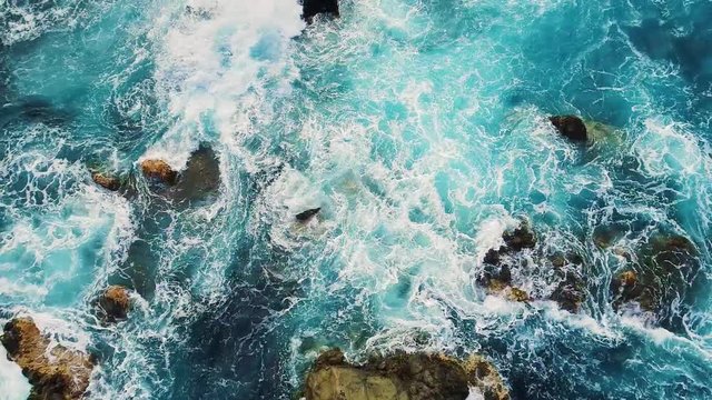 slow motion top down view of waves and clifs