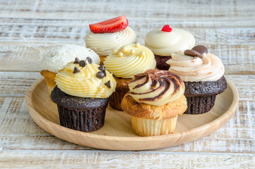 Tasty cupcake on wooden table on vintage background