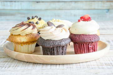 Tasty cupcake on wooden table on vintage background