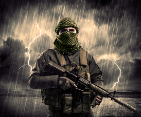 Dangerous armed terrorist with mask and gun in a thunderstorm with lightning