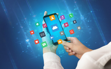 Hand using smartphone with application icons