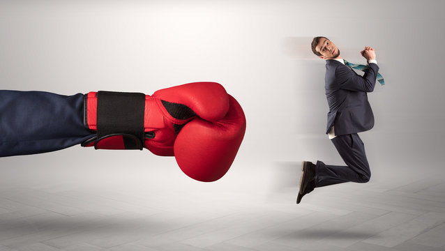 Giant hand gives a kick to a small businessman