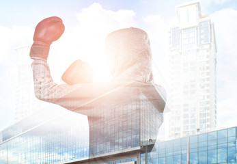 Double exposure of person with boxing gloves and cityscape background