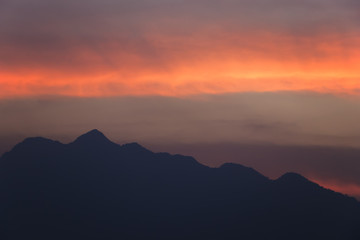 Fototapeta na wymiar silhouetted sunset sky with the mountains.beautiful orange clouds after sunset for background