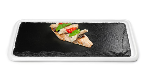 Slate plate with tasty bruschetta on white background