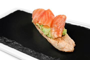 Slate plate with tasty bruschetta on white background