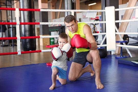 Little boy with trainer in boxing ring