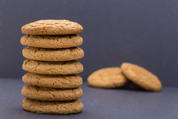 A stack of seven home made cookies - oat cookies on the background of black slate