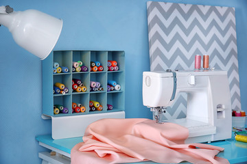 Sewing machine with fabric on table in tailor workshop