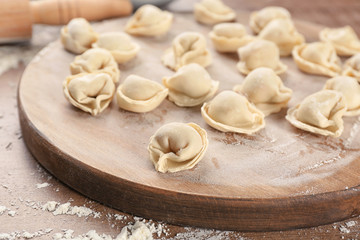 Raw dumplings on wooden board, closeup