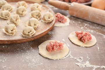 Preparation of dumplings with meat on table, closeup