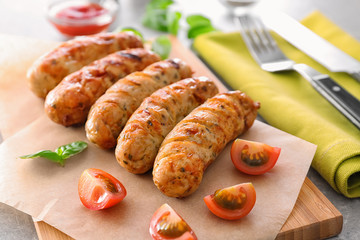 Delicious grilled sausages on wooden board