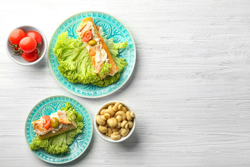 Plates with tasty chicken bruschettas on wooden table