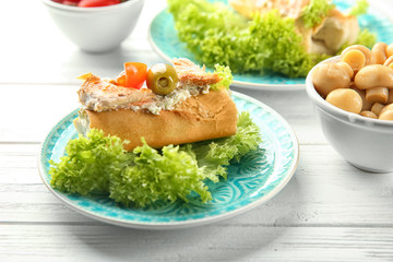 Plate with tasty chicken bruschetta on wooden table