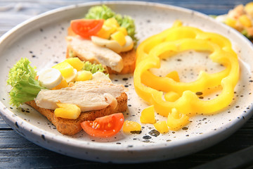 Plate with tasty chicken bruschettas, closeup