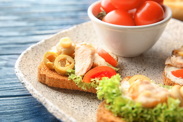Plate with tasty chicken bruschettas, closeup